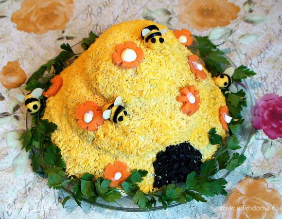 Смешать оставшийся желток с каплей майонеза и сформировать из него и порезанных на кружочки оливок пчел. Глазки сделать из черного перца горошком, крылья - из лепестков миндаля. Украсить салат цветочками из моркови, посадить на него "пчел", сделать для них дверцу из измельченных на терке оливок. Выложить вокруг салата зелень.