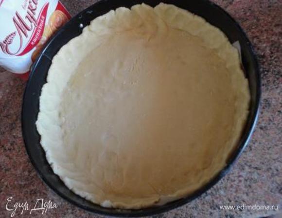 Включить духовку для разогрева до 180-200 градусов.
Дно формы, лучше разъемной, выстлать пекарской бумагой, а бока смазать маслом. Тестом выложить дно формы и сформировать бортики. Дно посыпать крахмалом.
