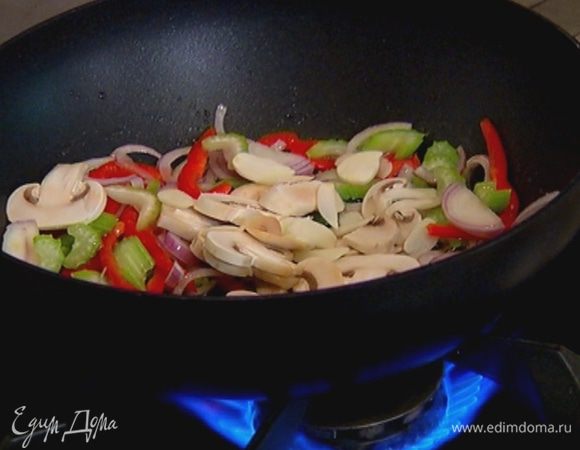 Чеснок почистить, нарезать пластинками, добавить в вок и все перемешать.