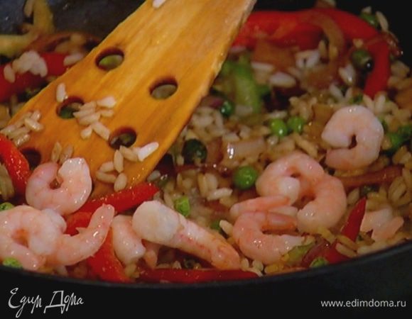 Слить из креветок солевой раствор и добавить их к рису с овощами. Все прогреть, перемешивая.
