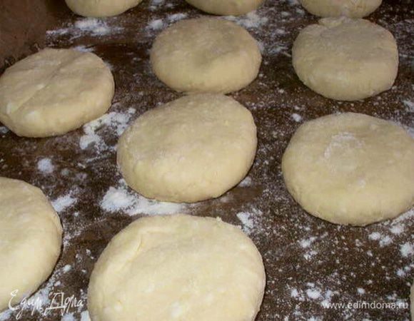 Сформировать сырники. И выложить на противень, застеленный пергаментной бумагой (предварительно смазать маслом и присыпать мукой).
