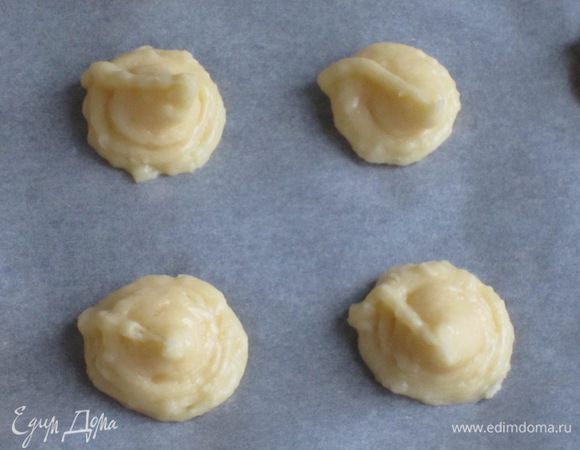 Переложить тесто в кондитерский мешок и выдавить шарики размером с грецкий орех на противень с пергаментом.
