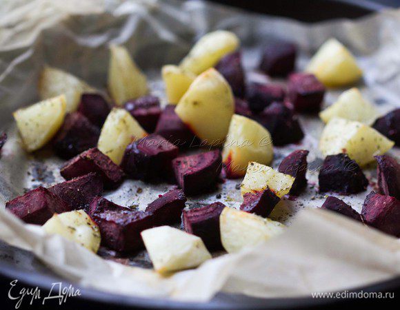 Картофель и свеклу почистить, нарезать на небольшие кубики и выложить в застеленную пекарской бумагой форму. Посолить, поперчить, сбрызнуть оливковым маслом и присыпать травами. Поставить запекаться на 20 минут в духовку при 200С.