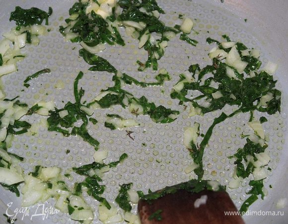 Готовим омлет со шпинатом. Если у вас замороженный шпинат, то сначала потушите его на сковороде без масла, чтобы испарилась жидкость, затем положить в сито и отжать. 
Разогреть половину сливочного масла, обжарить в нем лук и шпинат (если используете свежий, то начинайте с этого шага). 