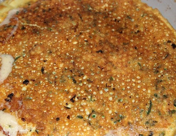 Влить оставшееся сливочное мало на сковороду, разогреть и перевернуть тарелку с омлетом неподрумяненной стороной вниз, подрумянить до готовности. 