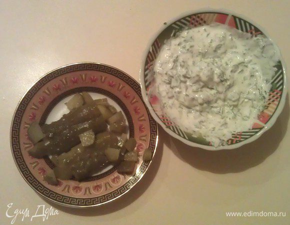 Снимаем наш омлет со сковороды на тарелку, фаршем кверху. В сметану добавляем нарубленную петрушку. Мелко нарезаем огурец. 