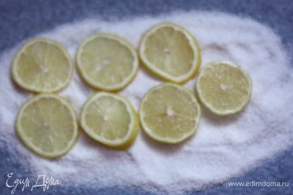На пергамент насыпем слой соли по размеру рыбины. Нарежем лимон кружочками и выложим на соль.