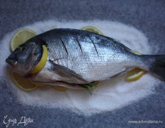 Один ломтик разрежем пополам и засунем их под жабры. Выложим рыбу на "подушку". Отправим в разогретую до 120-130 г духовку на 30-40 минут.