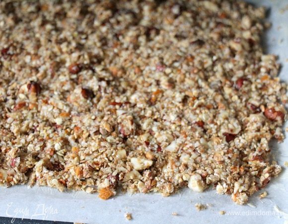 Перемешиваем смесь хлопьев и орехов с яблочно-карамельным соусом. Отправляем на противень покрытый бумагой для выпечки. Бумагу предварительно смазываем сливочным маслом. Распределяем гранолу по противню, плотно утрамбовывая рукой.