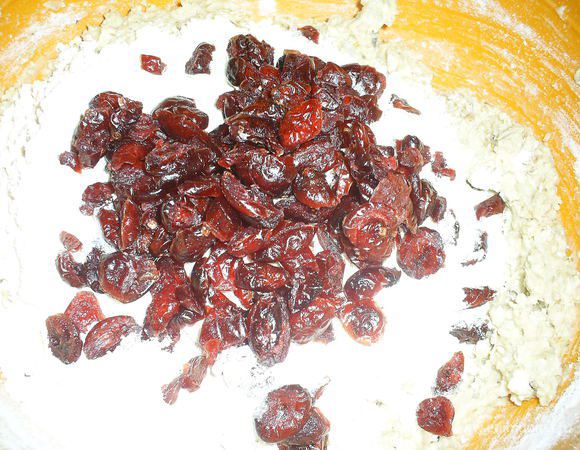 К полученной смеси добавляем муку с разрыхлителем, перемешиваем, добавляем измельченные овсяные хлопья.  Вымешиваем тесто, добавляем клюкву и перемешиваем, чтоб она равномерно по нему распределилась.