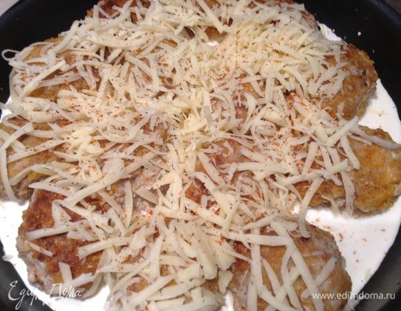 Переложить котлеты из сковороды в форму для выпечки, добавить сливки и посыпать сыром.