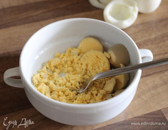 Из яиц удалить желтки и вилкой растереть их вместе с горчицей до однородного состояния. Добавить масло, уксус и тщательно всё смешать.
Белки мелко нарезать.