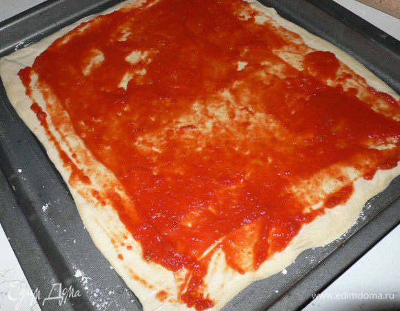 Сперва готовим дрожжевое тесто, как для пиццы. Можно взять и больше муки, зависит от личного вкуса. Мне больше нравится тонкая и хрустящая, а вообще разные пиццерии делают разной толщины. 
Слоеное тесто моего собственного приготовления, но можно и готовое. 
Когда тесто подоспеет можно приступать к основной части. 
Раскатывем тесто на размер противня. И оставляем на 30 минут для расстойки. 
Берем половину томатного пюре, подсоленное по вкусу и приправленное оливковым маслом , и распределяем по поверхности лопаткой или ложкой. Пюре должно быть достаточно густым. Я использовала готовое, так называемую Пассату, но она была жидкая и мне пришлось уварить. 
Ничего что края кривенькие, мы потом всё ножчиком выровняем )))