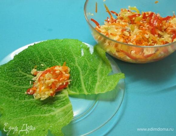 На каждом капустном листе вырезать утолщения, сделав V- образный надрез. В центр листа положить по 1,5-2 столовые ложки начинки.