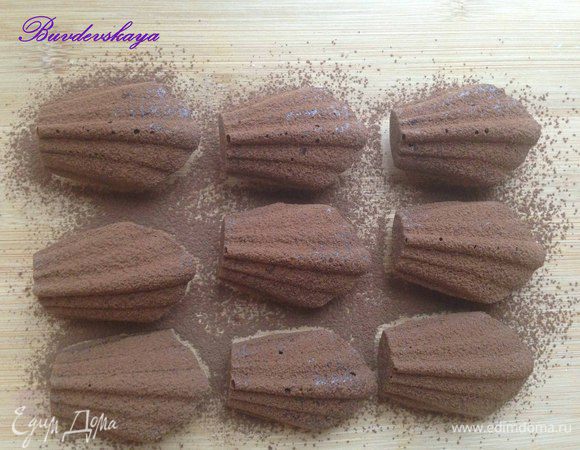 Вынуть из духовки и дать мадленкам немного остыть, затем перевернуть на разделочную доску и посыпать через мелкое сито какао порошком. Подавать можно слегка теплыми или холодными. ENJOY !