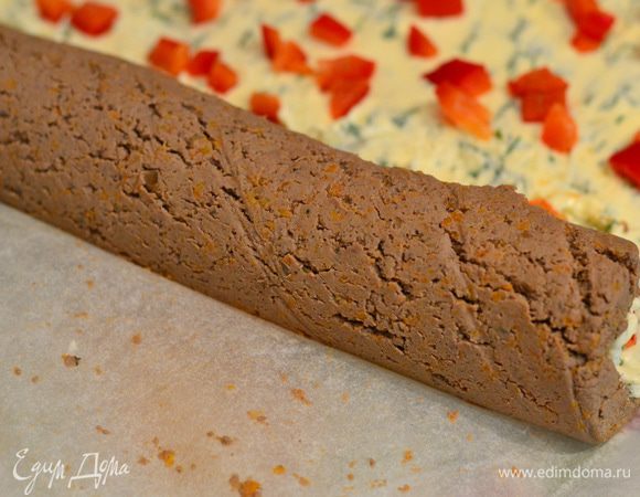 Начинаем аккуратно заворачивать рулет, помогая пергаментной бумагой, если будут трещинки, не беда, потом в холодильнике все хорошо застынет.