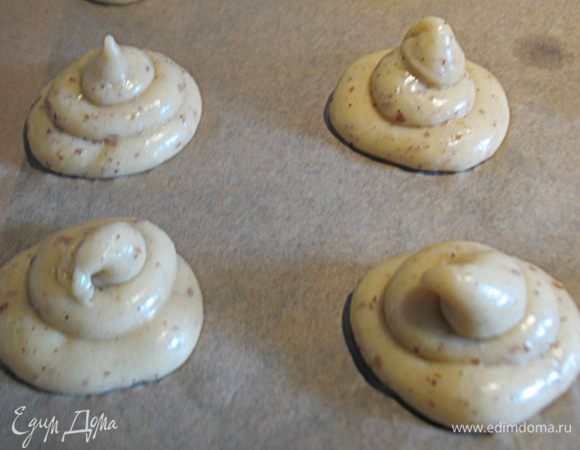 Застелить противень пергаментом, тесто поместить в кондитерский мешочек и с его помощью сформировать профитроли.  