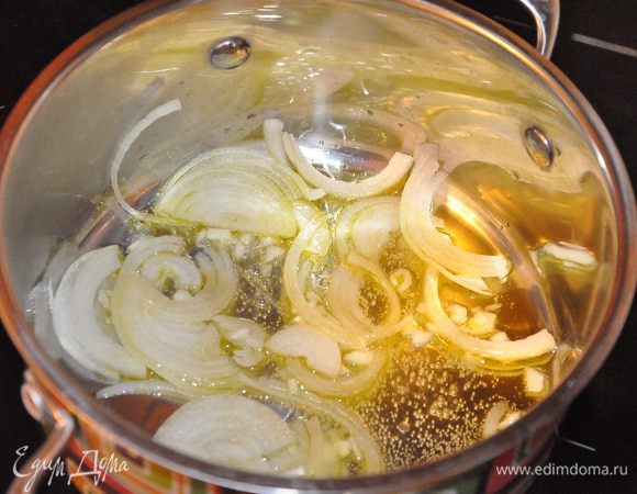 Разогрейте в кастрюльке, вместимостью 2 литра, оливковое масло, разогрейте, пассеруйте лук и чеснок на слабом огне минут 5, 