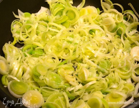 Лук порей вымыть и нарезать (только светлую часть) достаточно тонкими кольцами. В сковороде разогреть 2 ст.л. оливкового масла и положить обжариваться порей на пару минут. Затем добавить немного воды, накрыть крышкой и дать потомиться 10 минут. Время от времени перемешивать.  