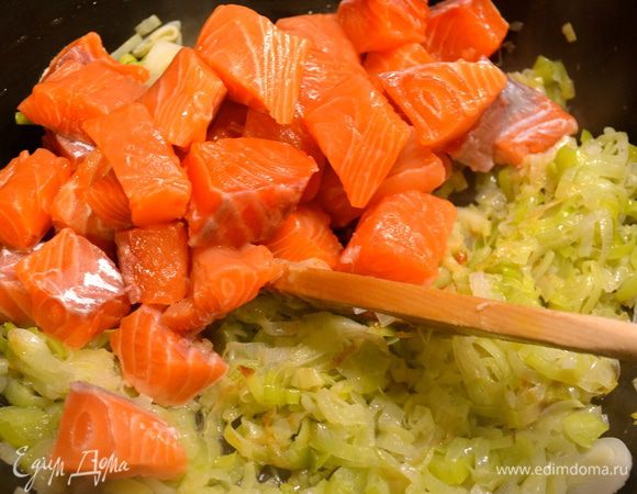 Филе семги очистить от кожи и нарезать небольшими кубиками. По истечении указанного времени добавить кусочки рыбы к луку. Обжарить пару минут на сильном огне, добавить белое вино и дать ему испариться.