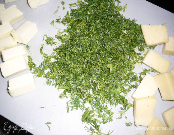 Укроп промыть и измельчить. Масло из холодильника или морозилки разделить на 7-10 кусочков (в зависимости от желаемого количества тефтелей), сыр разделить на такое же количество равных кусочков.