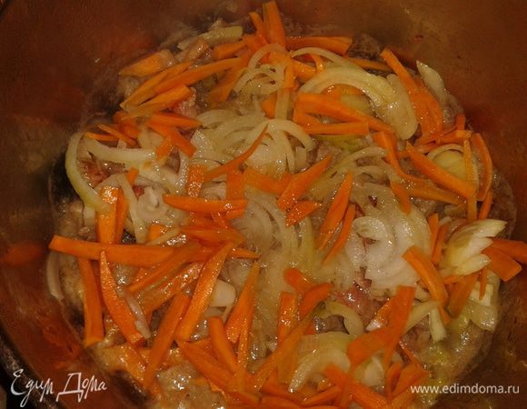 В мясо добавьте лук и морковь, нарезанные соломкой.