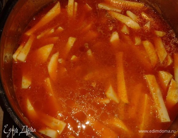 Тушить под крышкой до готовности мяса, затем добавить картофель,  воды, соли, перца, лаврового листа и пропущенного через чесноковыжималку чеснока. 