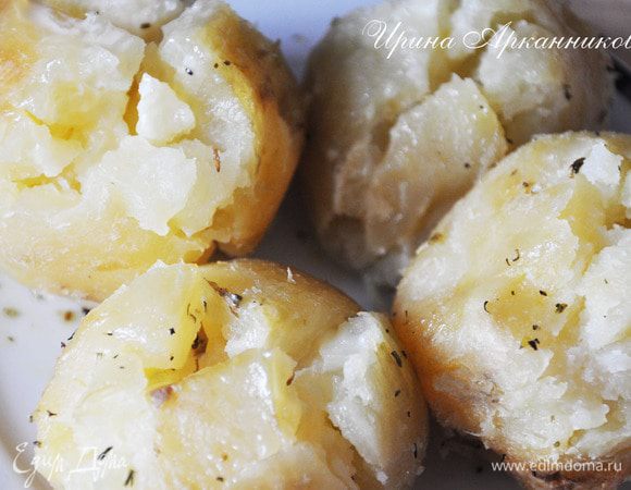 Сделать в картошке сверху небольшой надрез крест- накрест. Посолить обильно все, посыпать травами. Полить маслом. Перемешать хорошо и уложить обратно надрезами к верху. Поставить в разогретую до 180 гр духовку на 10-20 минут (зависит от размера картошки, конечно). При подаче полить домашней сметанкой.