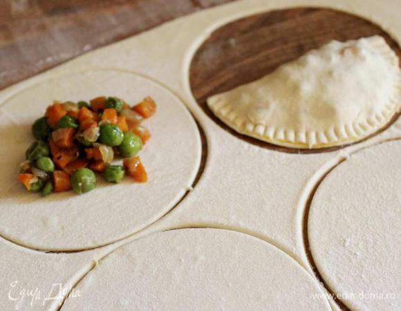 Тонко раскатать тесто. Вырезать круги (d=10-12 см) или нарезать тесто на квадраты. Выложить на тесто начинку (примерно 1,5 ст.л.), смазать края теста белком и скрепить края. Для верности закрепить края зубцами вилки.