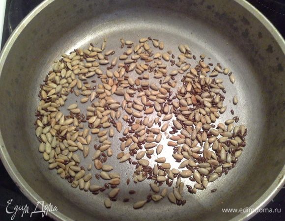 На сковороде немного обжарить семечки льна и подсолнечника. 