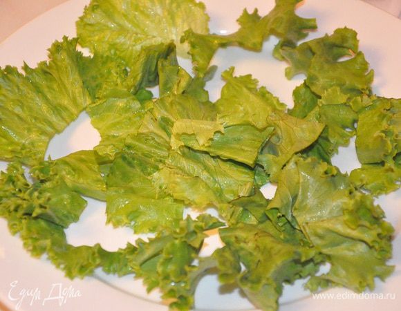 Листья салата промыть и разложить по тарелке. 