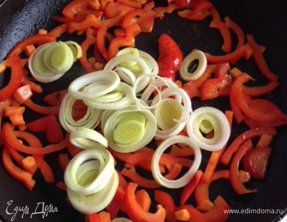 В глубокой сковороде разогреть кунжутное масло, обжарить на небольшом огне в течение 5 минут сладкий перец, затем добавить лук порей - обжаривать еще в течение 2-3 минут.