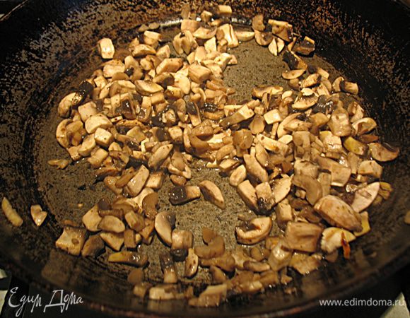 Сковороду поставить на огонь и кладем туда измельченные грибы. Обжаривать грибы до испарения жидкости. Грибы посолить, поперчить, добавить специй на ваш вкус. 