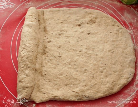 Тесто выложите на подпыленную мукой поверхность,расплющите его.Срутите тесто в плотный рулет,запечатывая на каждом витке ребром ладони.