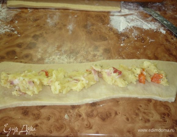 Берем в руки штангу... пардон... скалку. Тесто обомнем нежно. раскатаем. От теста отрезаем полосочки шириной... да какая разница. Какие хочется. Ориентируйтесь на количество начинки. У меня были полоски см по 10. Вдоль полос равномерно раскладываем (или размазываем) начинку. Краешки слегка защипываем.