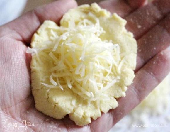 На ладони распределить 1 ст.л. с горкой теста, уложить на лепёшку 1-1,5 ч.л. сыра.