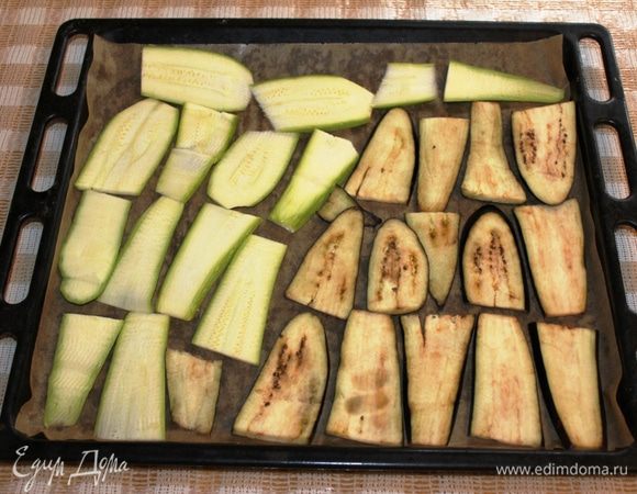Разогреть духовку до 180 градусов. Противень застелить пергаментом и выложить кусочки баклажана и кабачка. Запекать минут 15. 