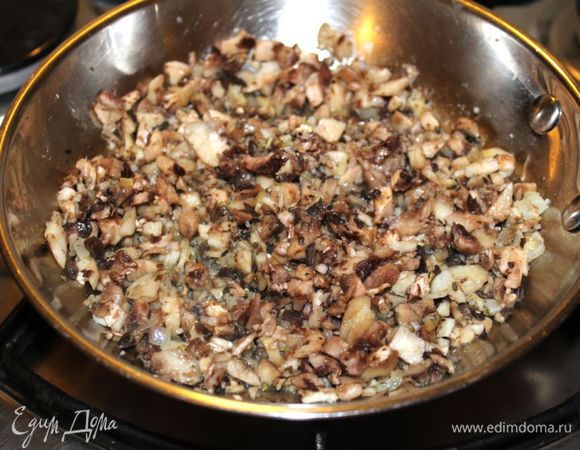 К луку отправить порезанные грибы, посолить, поперчить. Томить на среднем огне под крышкой 4-5 минут.
