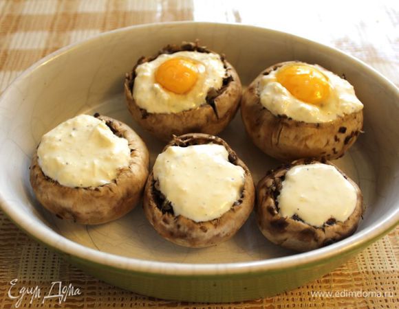 Тертый сыр смешать со сметаной, присолить и поперчить. В подготовленные шляпки грибов уложить томленные грибы, сверху добавить 2 ч.л. сметанной заправки на каждый гриб. Сделать углубление в двух шляпках и аккуратно положить по яйцу перепелиному. Запекать при температуре 170 градусов 15-20 минут.
