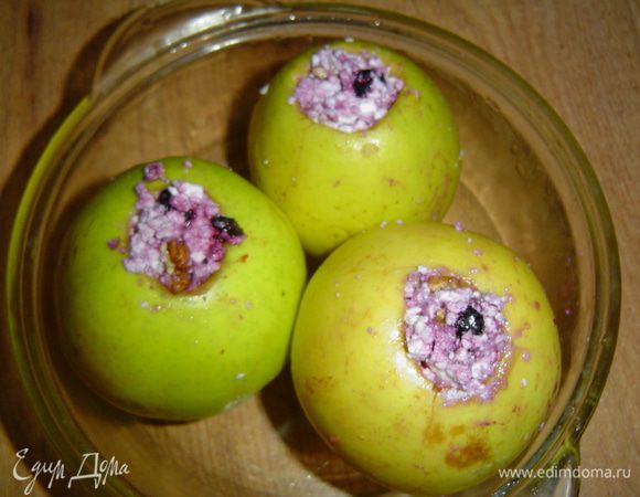В отверстия яблок кладем по чайной ложке меда, а остальное пространство заполняем подготовленной творожной массой. 