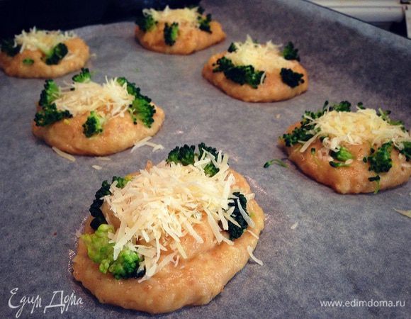 На противень выстеленный пекарской бумагой и смазанный маслом выкладываем ложкой небольшие лепешечки ,на каждую лепешку немного брокколи и горсточку сыра ....