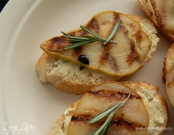 Кусочки багета намазать сырной массой, сверху выложить слайсы груши. Смазываем груши медом, украшаем розмарином. Добавляем бальзамический крем. Подаем к шампанскому или белому вину. Сладость груши, нежность сыра, аромат розмарина создает восхитительный вкус. Приятного аппетита!