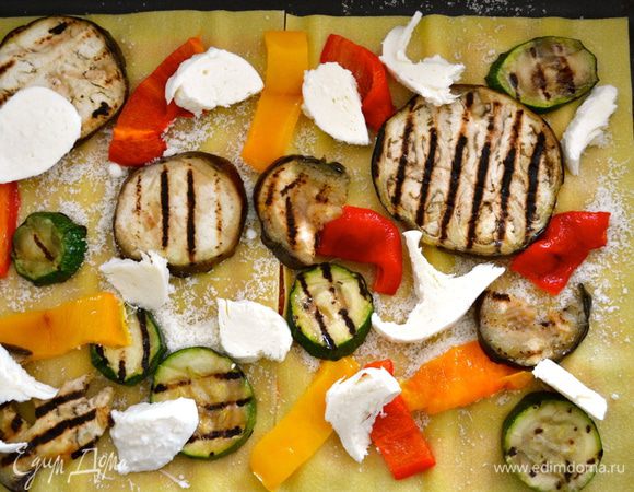 Присыпаем немного тертым сыром, и выкладываем слой овощей, в произвольном виде... Сверху кладем кусочки сыра моцарелла.