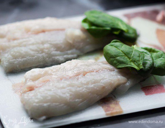 Филе натираем солью и смесью перцев. На хвостовую часть с внутренней стороны выкладываем 4-5 листочков шпината. 