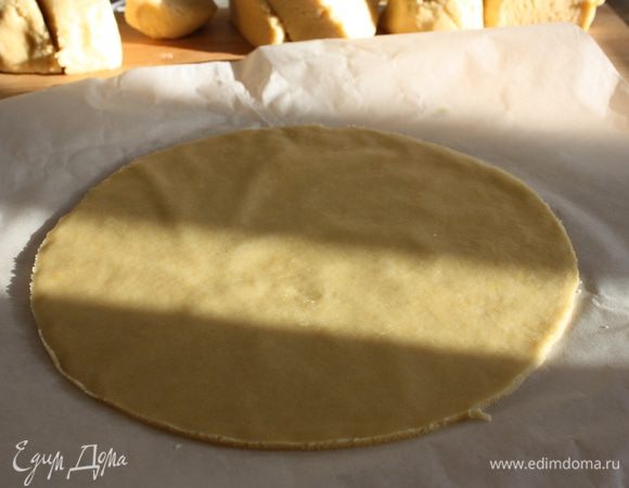 Разделить тесто на 7 частей, каждую часть раскатать толщиной 0,5 см, обрезать по кругу и выпекать до золотистого цвета при температуре 180°С   10-15 минут. Обрезки запечь немного дольше для использования на обсыпку торта.