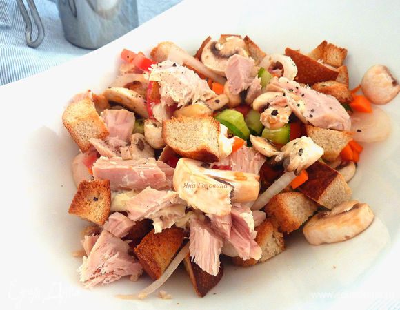 На овощи выложить тунец и сухарики.
