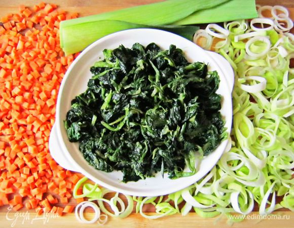 Подготовить овощи. Разморозить шпинат. Морковь вымыть, почистить и нарезать мелкими кубиками.
Лук-порей очистить, вымыть и нарезать тонкими кольцами.