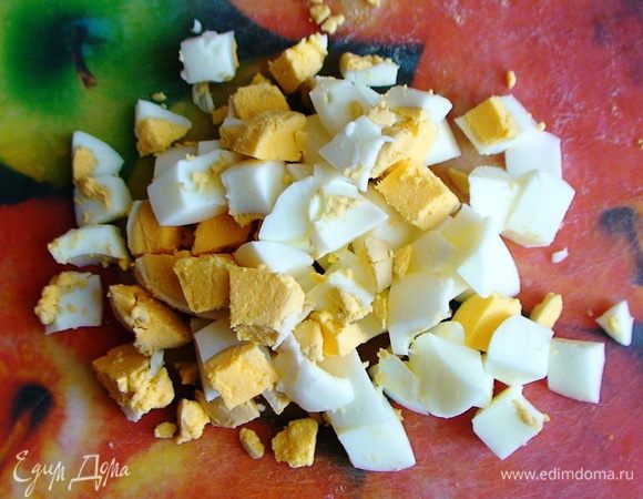 Яйца порезать кубиками. Маслины разрезать напополам.