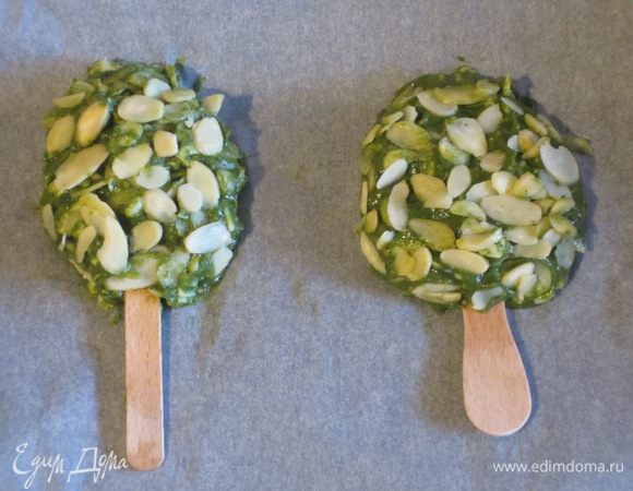 В чаше миксера соединить салат латук, шпинат, морковь, картофель и измельчить массу. Добавить сыр, яичный желток, посолить и хорошо перемешать. Столовой ложкой взять овощную массу, сформировать "эскимо", вставить деревянные палочки, обвалять в миндальных хлопьях и выложить на противень с пергаментом.