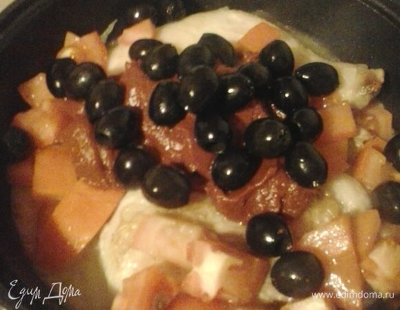 Куски курицы складываем в казан, заливаем бульоном и вином. Кипятим минут 5, пока не выпарится алкоголь. Затем добавляем нарезанные кубиком лук, помидоры, морковь, нарезанную соломкой, томатную пасту и оливки. Убавляем огонь, накрываем крышкой и тушим 60 минут.